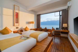 um quarto de hotel com duas camas e uma grande janela em Manwu Dali Jimu Boutique Guesthouse em Dali