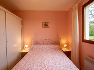 a bedroom with a bed with two lamps on two tables at Maison charmante avec terrasse, jardin clos et animaux acceptés - FR-1-616-90 in Saint-Martin-de-Ribérac
