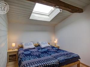 Ένα ή περισσότερα κρεβάτια σε δωμάτιο στο Maison spacieuse avec terrasse, jardin et poêle à bois à Saint-Héand - FR-1-496-146