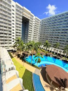 a large hotel with a swimming pool and a large building at Shell Residences Condotel by PauL in Manila