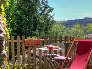 einen Tisch und Stühle auf einer Terrasse mit einem Zaun in der Unterkunft Studio Montagne Paisible, Terrasse, Animaux Bienvenus - FR-1-496-224 in Saint-Priest-la-Prugne + 21 Fotos
