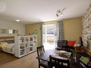 ein Wohnzimmer mit einem Bett und einem Esstisch in der Unterkunft Studio Montagne Paisible, Terrasse, Animaux Bienvenus - FR-1-496-224 in Saint-Priest-la-Prugne