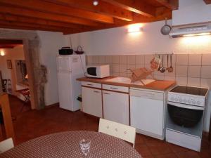 a small kitchen with white appliances and a table at Charmant gîte avec poêle à bois, terrasse et jardin, sentiers rando, 1 chambre + mezzanine - FR-1-496-256 in Véranne