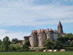 a large castle with a tower on top of a field at Gîte calme avec terrasse et animaux acceptés - FR-1-496-47 in Sainte-Foy-Saint-Sulpice
