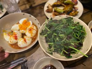 a table with three plates of food and a salad at Sóc House Măng Đen in Kon Plong