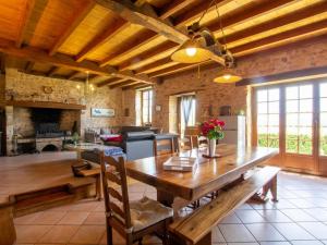 Un gran comedor con una mesa de madera en una habitación. en Gîte charmant avec jardin et cheminée à 2 km de Cherveix-Cubas, proche sites préhistoriques et nautiques - FR-1-616-158, en Cherveix-Cubas