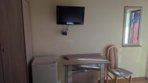 a room with a desk and a television on the wall at В Гостях на Иссык-Куле 2 in Cholpon-Ata