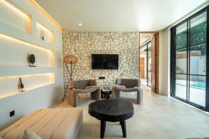 ein Wohnzimmer mit Sofa und Tisch in der Unterkunft Dreamy 2BR pool villa, steps from Gili Air beach in Gili Air