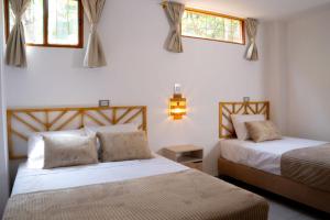 a bedroom with two beds and two windows at Hospédate en Oiba con estilo in Oiba