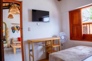 a bedroom with a table and a tv on the wall at Hospédate en Oiba con estilo in Oiba