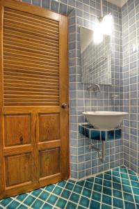 ein Bad mit einem Waschbecken und einem Spiegel in der Unterkunft Saeng Panya Home SHA Plus in Chiang Mai