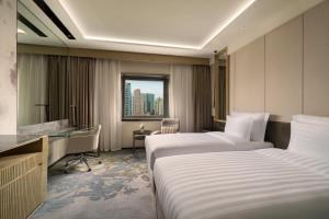 北京市にあるKempinski Hotel Beijing Yansha Centerのベッド2台と机があるホテルの部屋