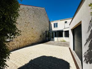 an empty driveway in front of a brick building at Spacieuse Maison 4 Chambres, Centre Fouras, Proche Plages - FR-1-709-96 in Fouras