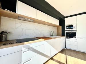 a kitchen with white cabinets and a sink at Charmante maison familiale pour 10 personnes, spacieuse et confortable - FR-1-309-511 in Banyuls-sur-Mer