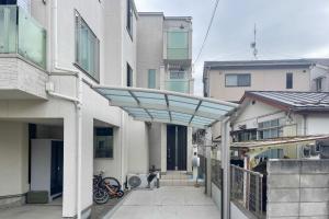 东京Nishiikebukuro Pure Gray Villa的两栋建筑之间走道上的遮阳篷