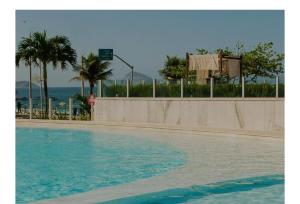 a swimming pool with palm trees and a basketball hoop at Hotel Nacional in Rio de Janeiro
