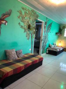 a bedroom with two beds and a tree mural on the wall at Maracaípe Cantinho Vida Boa in Porto De Galinhas +53 photos