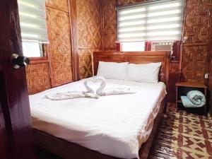 een slaapkamer met een bed met witte lakens bij Taylor Plantacion Resort - Bamboo Villa in Tangaro +26 foto's