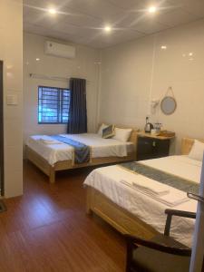 a hotel room with two beds and a window at Hai Dang Hotel in Can Tho +7 photos