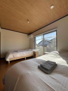 a bedroom with two beds and a large window at Long-term stays welcome! Entirely private rental townhouse for up to 4 people, 17 minutes walk from station, 45 minutes direct to Tokyo in Ageo