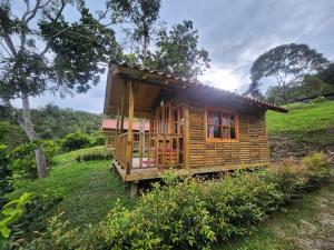 una pequeña casa de madera en una colina en un campo en Finca Villa Julia, en La Vega