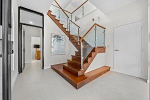 a staircase in a house with wood and white walls at Silver Sands Sanctuary - 6BR Beachside Luxury in Mandurah