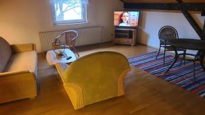 a living room with a couch and a table and a tv at Ferienwohnung Jochen Riederer in Neualbenreuth