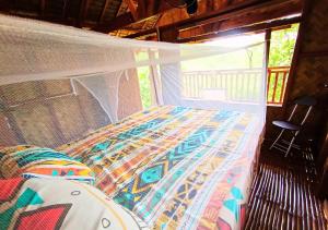 a bed with a canopy in a room with a window at Busuanga Nature Retreat in Busuanga