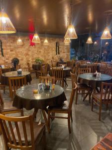 a dining room with tables and chairs and lights at Pousada dos Artistas in Campina Grande
