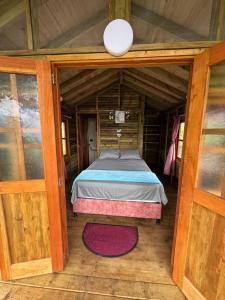 a bedroom with a bed in a wooden house at Finca Villa Julia in La Vega +8 photos