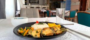 a plate of food with rice and vegetables on a table at OLA LUXURY HOTEL Parakou in Parakou