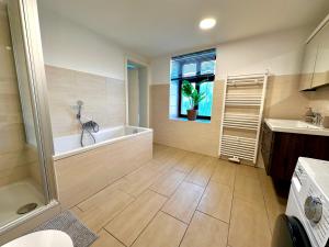 ein großes Bad mit einer Badewanne und einem Fenster in der Unterkunft KERA STAY - Apartments Merseburg in Merseburg + 35 Fotos