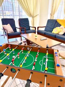 a coffee table with a soccer game on it in a living room at Double Storey 4 room - Walk to Jonker Street #9pax in Melaka