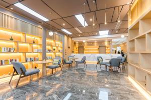 a waiting area with chairs and tables in a library at Atour Hotel Suzhou Wangting in Suzhou