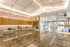 a lobby of a building with couches and tables at Atour Hotel Suzhou Wangting in Suzhou