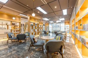 a library with chairs and tables and bookshelves at Atour Hotel Suzhou Wangting in Suzhou
