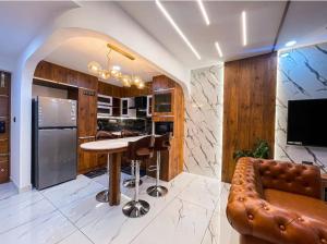 eine Küche mit einer Bar, einem Tisch und einem Sofa in der Unterkunft The Pink Luxe Apartment in Thiruvananthapuram