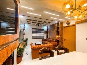 eine Lobby mit einem Sofa und einem Tisch und Stühlen in der Unterkunft The Pink Luxe Apartment in Thiruvananthapuram + 42 Fotos