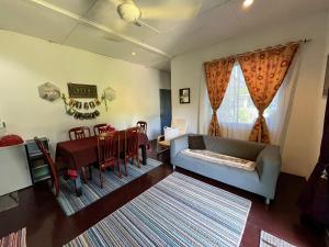 クチンにあるSri Kandis Cottage Stayのリビングルーム(ソファ付)、ダイニングルーム