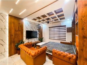 ein Schlafzimmer mit einem Bett und einer Couch und einem Fernseher in der Unterkunft The Pink Luxe Apartment in Thiruvananthapuram