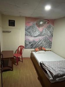 una camera con un letto e un dipinto sul muro di Lake forest guest house a Pokhara