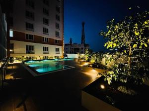ein Gebäude mit Pool im Innenhof in der Nacht in der Unterkunft The Pink Luxe Apartment in Thiruvananthapuram