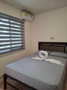 a bedroom with a bed with two white towels on it at Finca Agroturística La Amistad in Churuquita Grande
