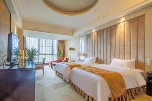 a hotel room with two beds and a television at Sichuan Tennis International Hotel Main Building in Chengdu