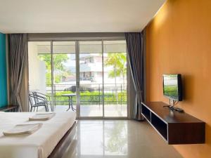 Schlafzimmer mit einem Bett, einem TV und einem Balkon in der Unterkunft The Living Pool Villas in Ban Ko Khwan