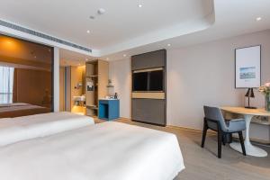 a hotel room with a bed and a desk and a table at Atour Hotel Suzhou Wangting in Suzhou
