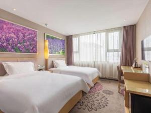 Una habitación de hotel con dos camas y un escritorio. en Lavande Hotel Jinan Quancheng Road Baotu Spring Branch, en Jinan
