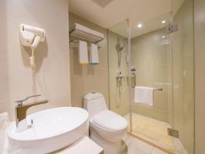 a bathroom with a toilet and a shower and a sink at City Comfort Inn Wuhan Guanggu Software Park in Wuhan