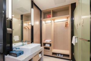 a bathroom with a sink and a mirror at Echarm Hotel Liuzhou Liunan Wanda Plaza in Liuzhou +139 photos
