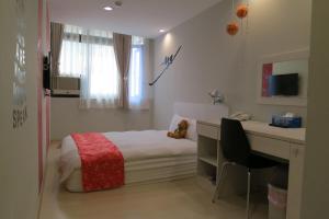 a small bedroom with a bed and a desk at 茶源旅店 in Yuchi